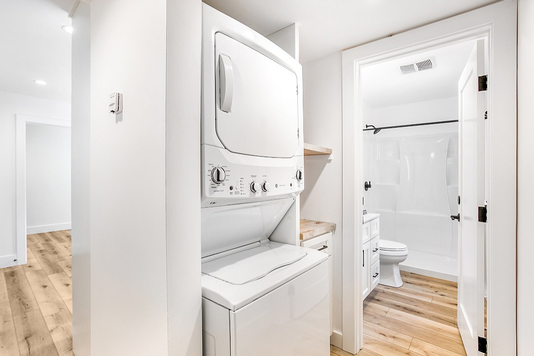 Modern apartment hallway featuring an in-unit washer and dryer.