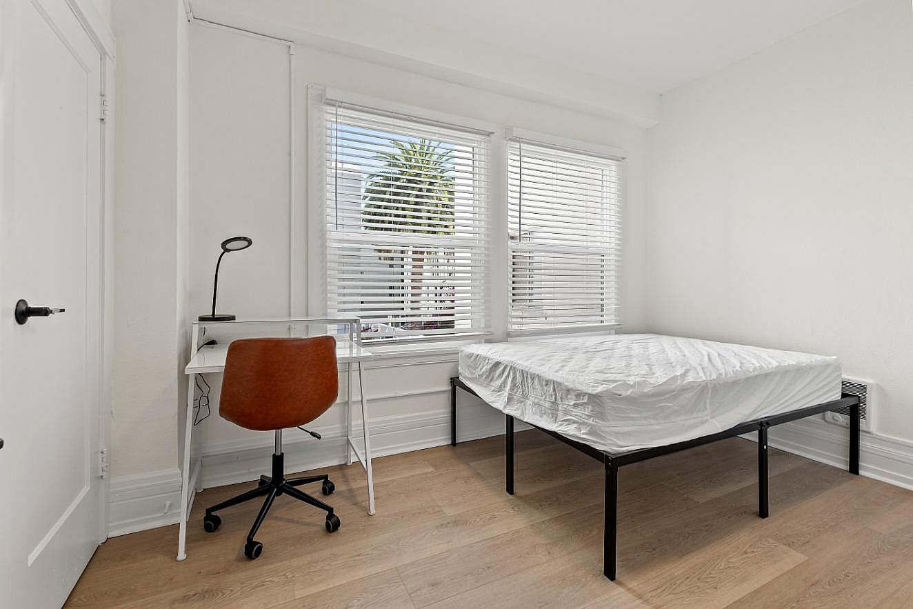 Spacious bedroom including a practical desk and chair for everyday productivity