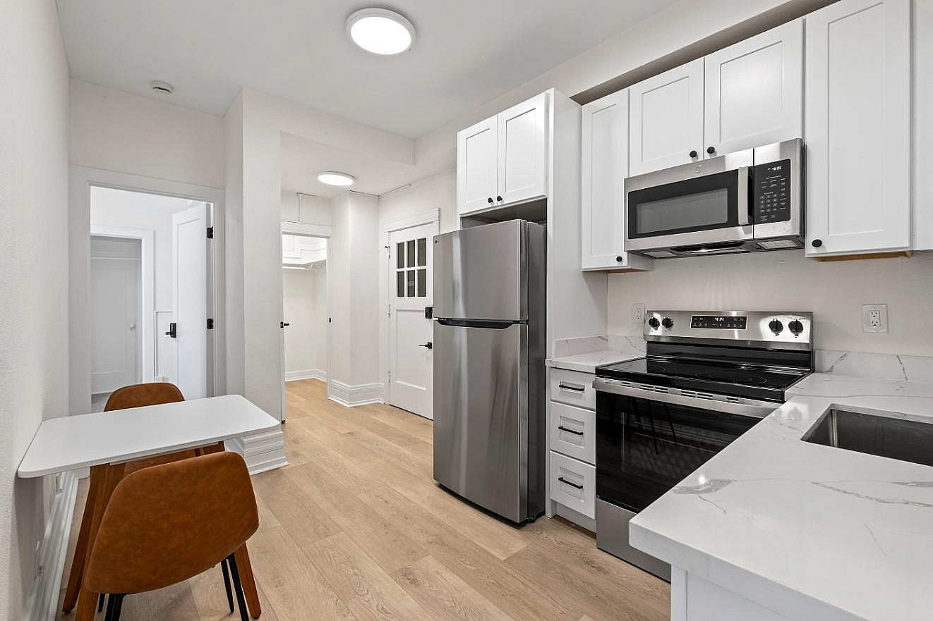 Open-concept dining area paired with a modern kitchen featuring sleek stainless steel appliances