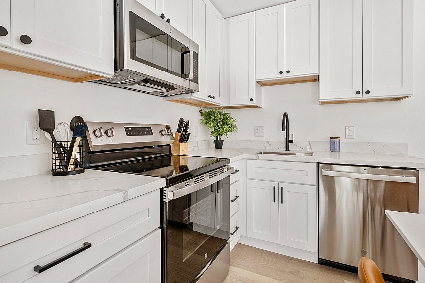 Elegant kitchen with sleek stainless steel appliances, modern white cabinetry, and polished countertops.