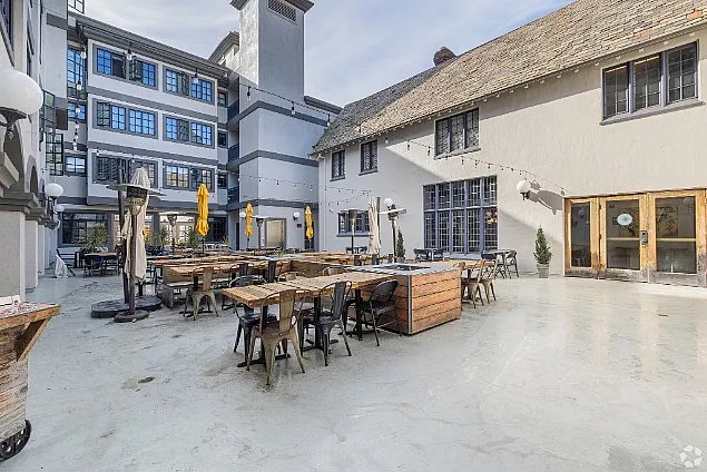 Charming courtyard with outdoor seating, string lights, and historic architecture, perfect for relaxing and social gatherings.