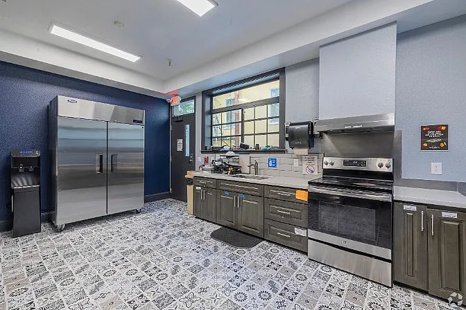 Modern kitchen with sleek stainless steel appliances, elegant cabinetry, and stylish patterned flooring.