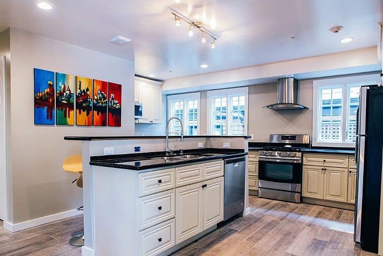 Modern kitchen with elegant cabinetry, stainless steel appliances, and vibrant artwork on the walls creating a welcoming vibe.