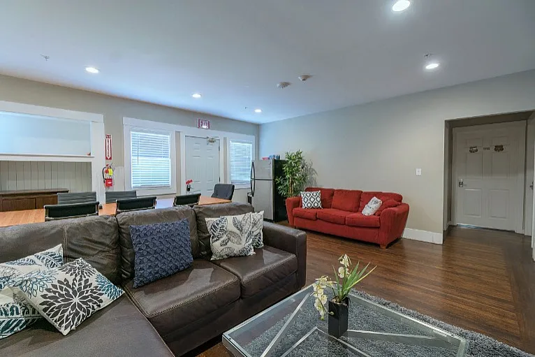 Inviting modern living room with cozy seating, stylish decor, and open dining area on elegant wooden floors.