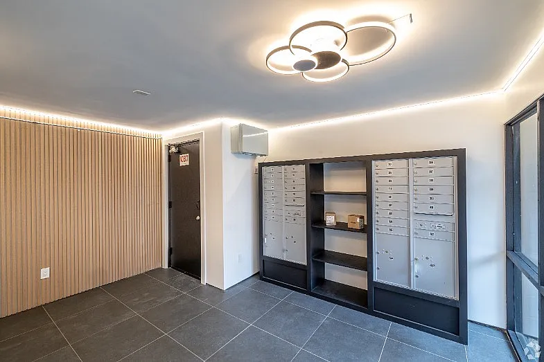 Mailroom with lockers and modern lighting in a stylish apartment building.