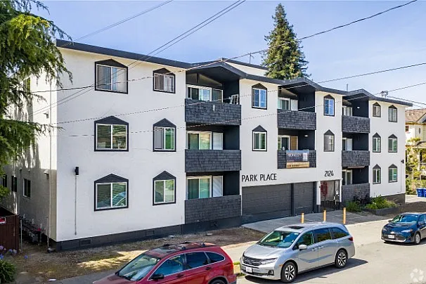 Modern apartment building with multiple balconies and ample parking, featuring a stylish exterior design at Park Place.