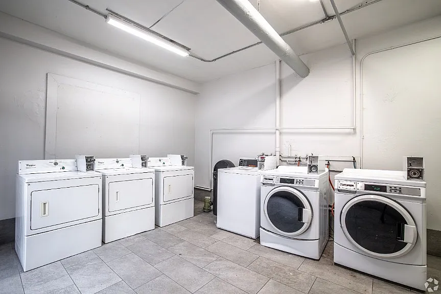 Spacious laundry room featuring modern washing machines and dryers.