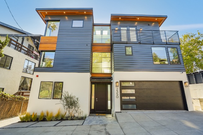Modern three-story home with sleek architectural design, large windows, and a spacious garage set in a serene neighborhood.