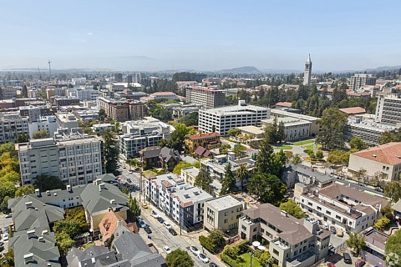 Scenic aerial view of a vibrant urban neighborhood with modern architecture, lush greenery, and a dynamic skyline.