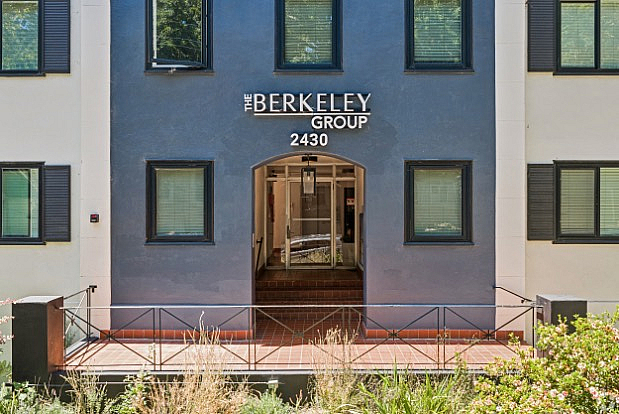 Charming building entrance of The Berkeley Group with modern facade and lush landscaping.
