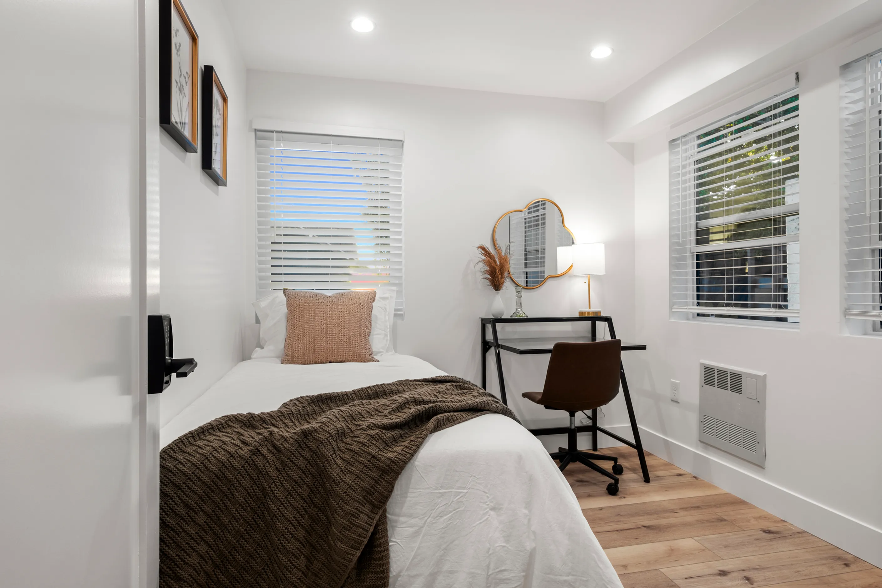 Inviting bedroom with a single bed, decorative pillows, and a modern workspace.