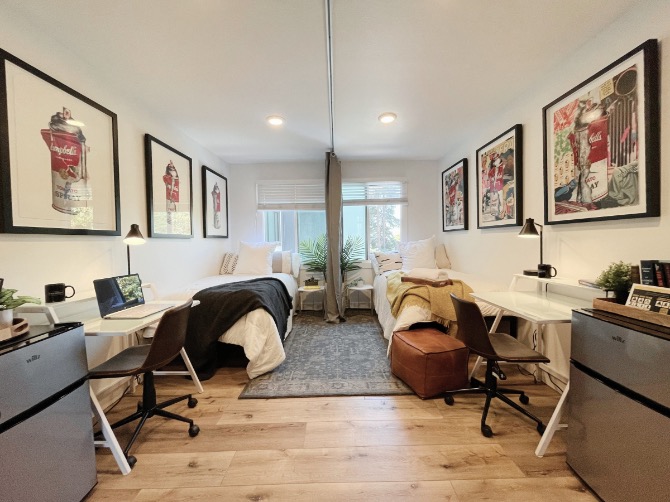 Chic and modern dual bedroom workspace featuring cozy beds, sleek desks, and vibrant artwork, perfect for students.