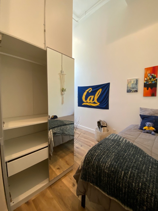 Cozy bedroom with stylish decor, featuring a large mirror, a comfortable bed, and elegant wall art.