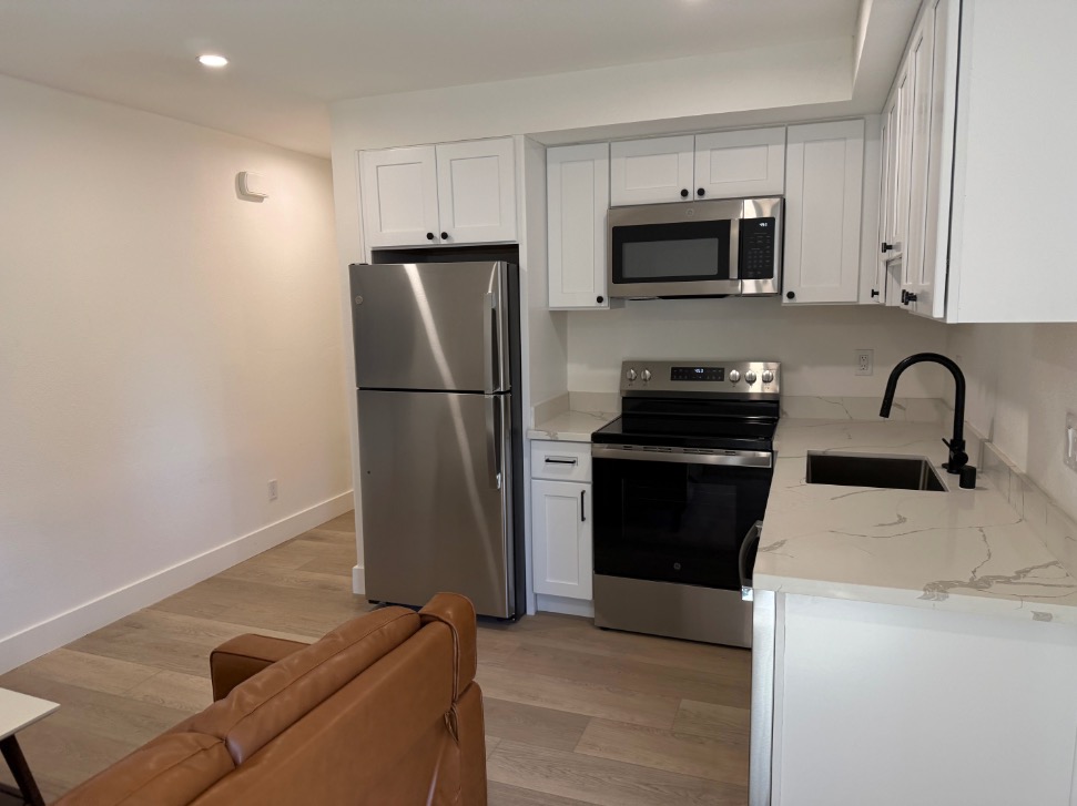 Modern kitchen with sleek stainless steel appliances, elegant countertops, and white cabinetry, offering a stylish and functional cooking space.