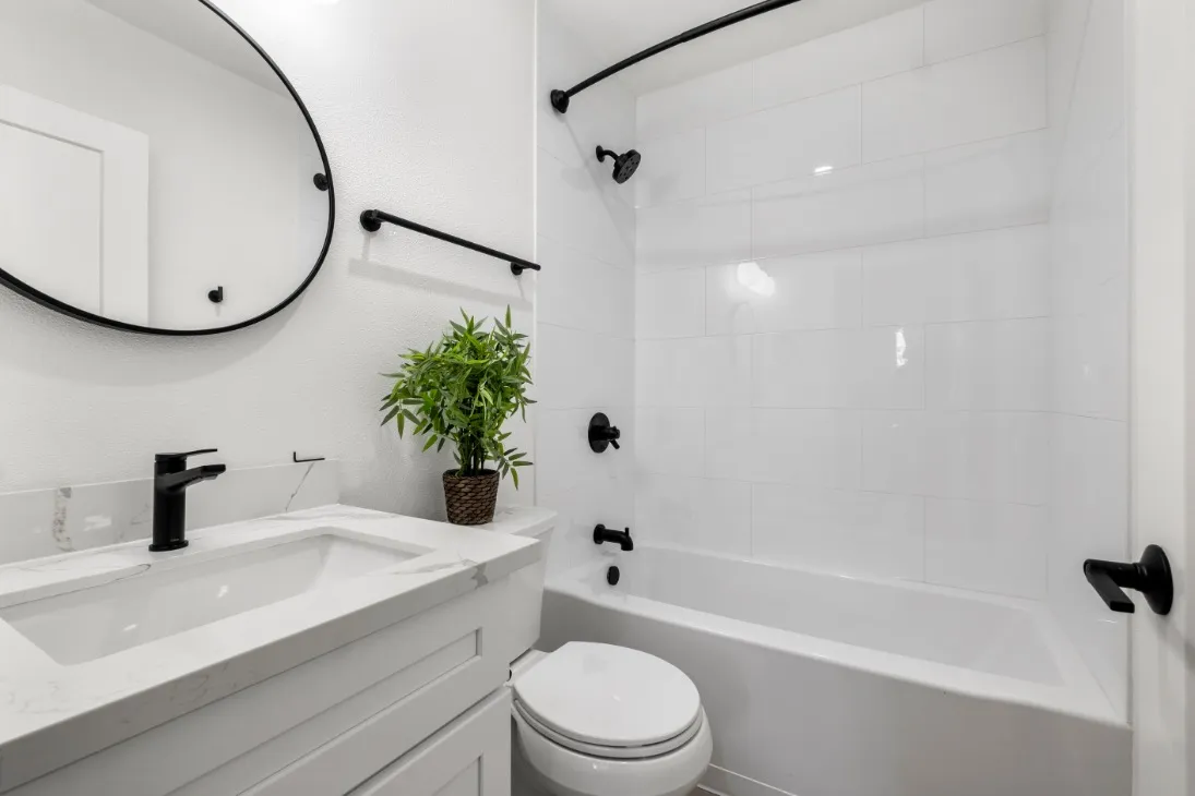 Chic modern bathroom with sleek black fixtures, and white tiles.