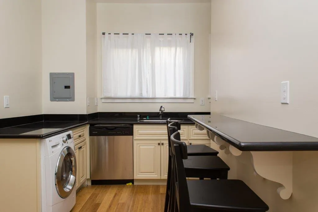 Charming kitchen with sleek black countertops, modern appliances, and a cozy breakfast bar with seating.