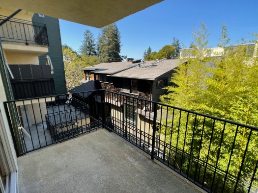 Inviting balcony with scenic views of lush greenery and charming neighboring homes.