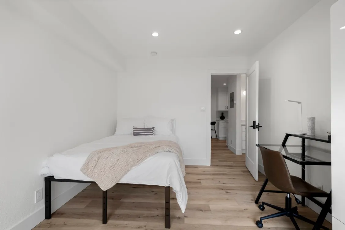 Cozy bedroom with a comfortable bed, stylish decor, and a compact work desk, perfect for relaxation and productivity.
