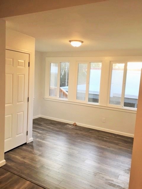 Bright and airy interior space with large windows and elegant wooden flooring.