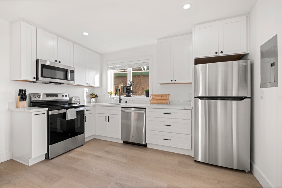 Modern kitchen with sleek stainless steel appliances, bright cabinetry, and elegant countertops, offering a stylish and functional cooking space.