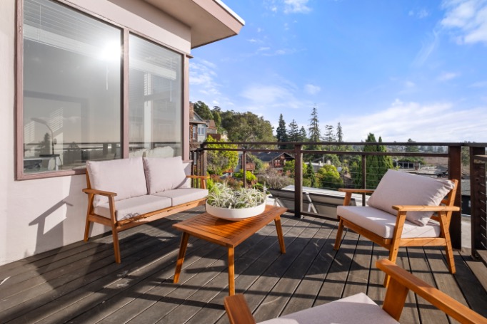 Charming outdoor patio featuring modern wooden furniture, offering stunning panoramic views.