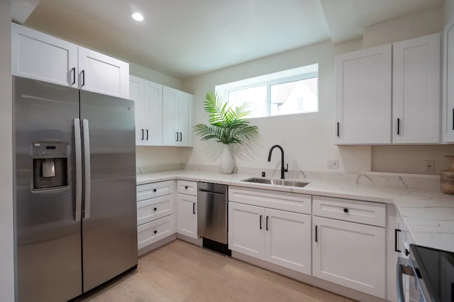 Modern kitchen with sleek stainless steel appliances, elegant white cabinetry, and a bright, airy atmosphere enhanced by natural light.