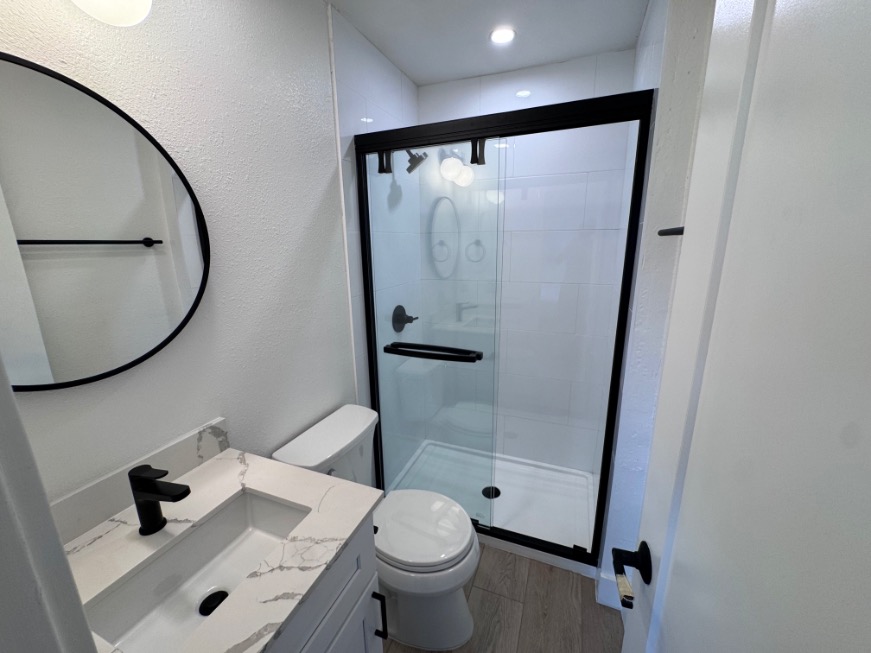 Sleek modern bathroom with a chic glass shower, elegant vanity, and stylish black fixtures.