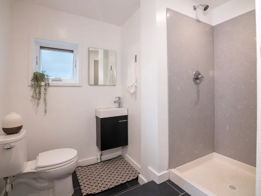 Modern bathroom design featuring sleek shower space, stylish vanity, and elegant decor with natural accents.