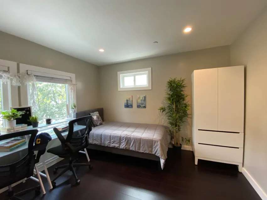 Bright and cozy bedroom with a large window, modern decor, and a comfortable bed, perfect for relaxation.