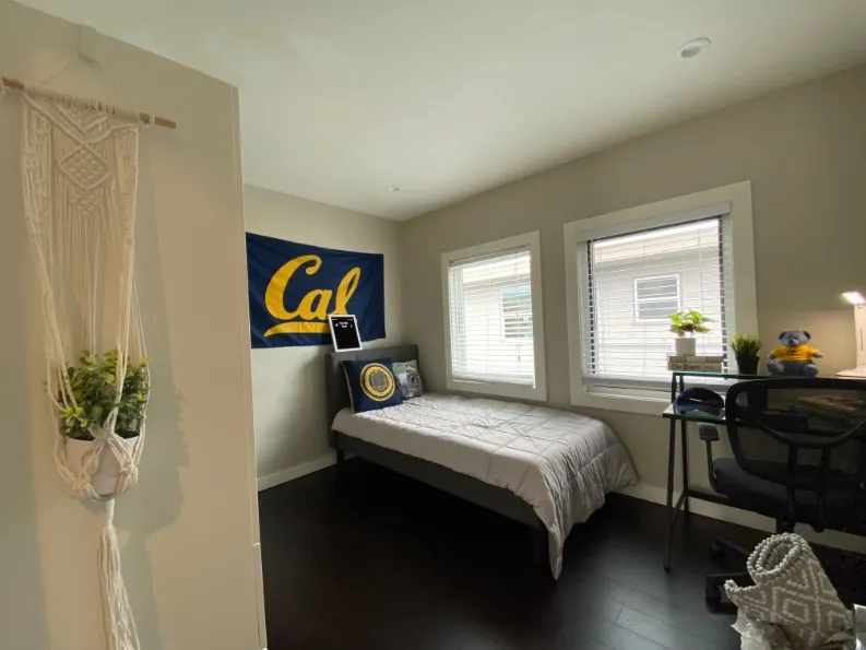 Inviting student bedroom with modern decor, featuring a cozy bed, study desk, and bright natural lighting.