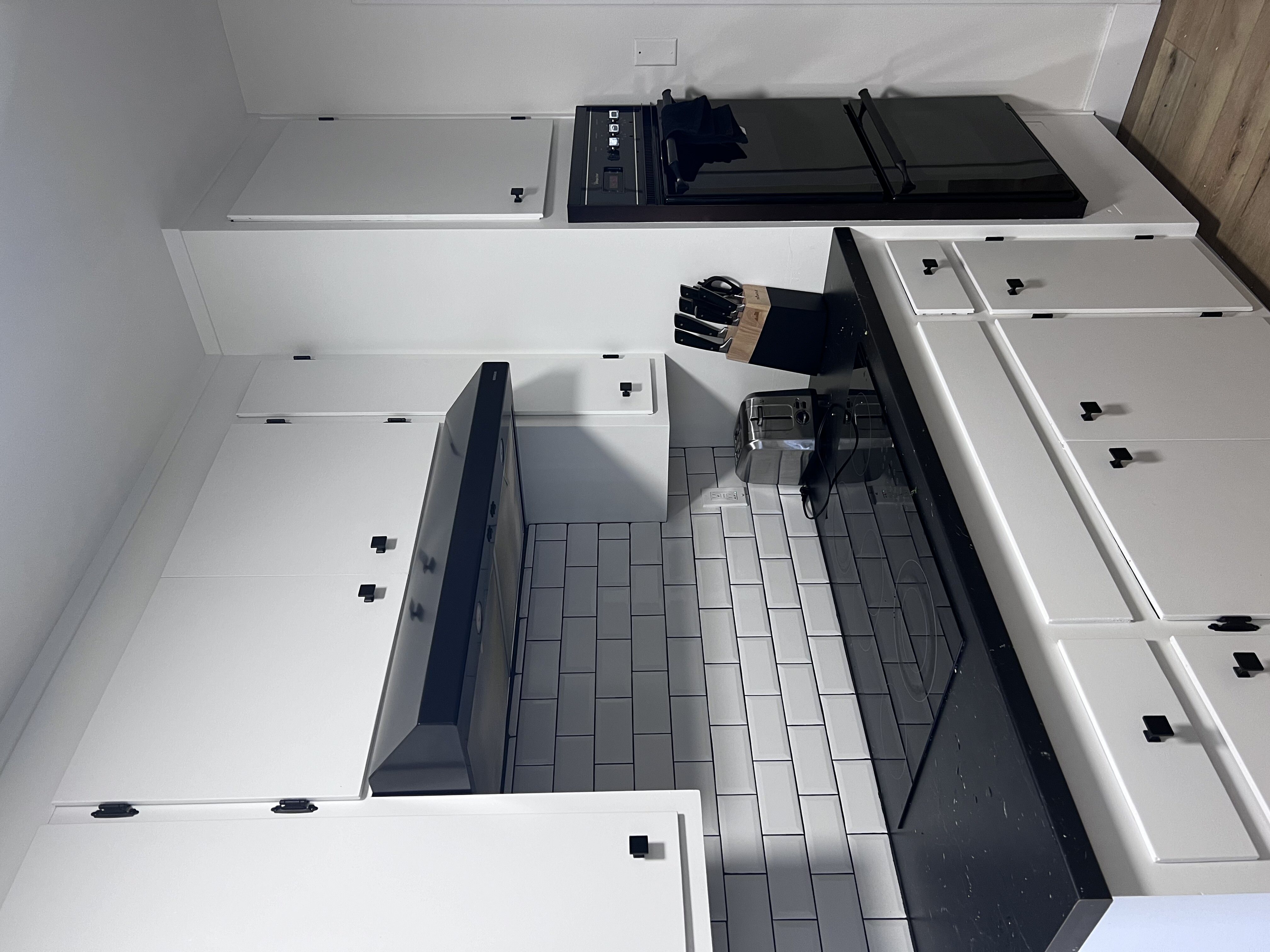 Modern kitchen with sleek black countertops, white cabinets, and subway tile backsplash offering a stylish and functional cooking space.