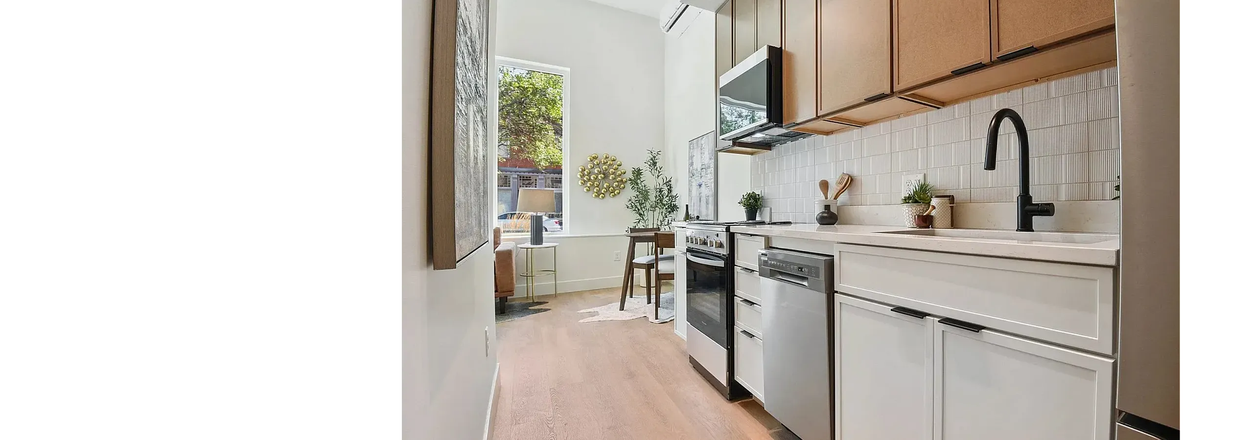 Bright and modern kitchen with sleek cabinetry, stainless steel appliances, and charming dining nook, featuring a large window for natural light.