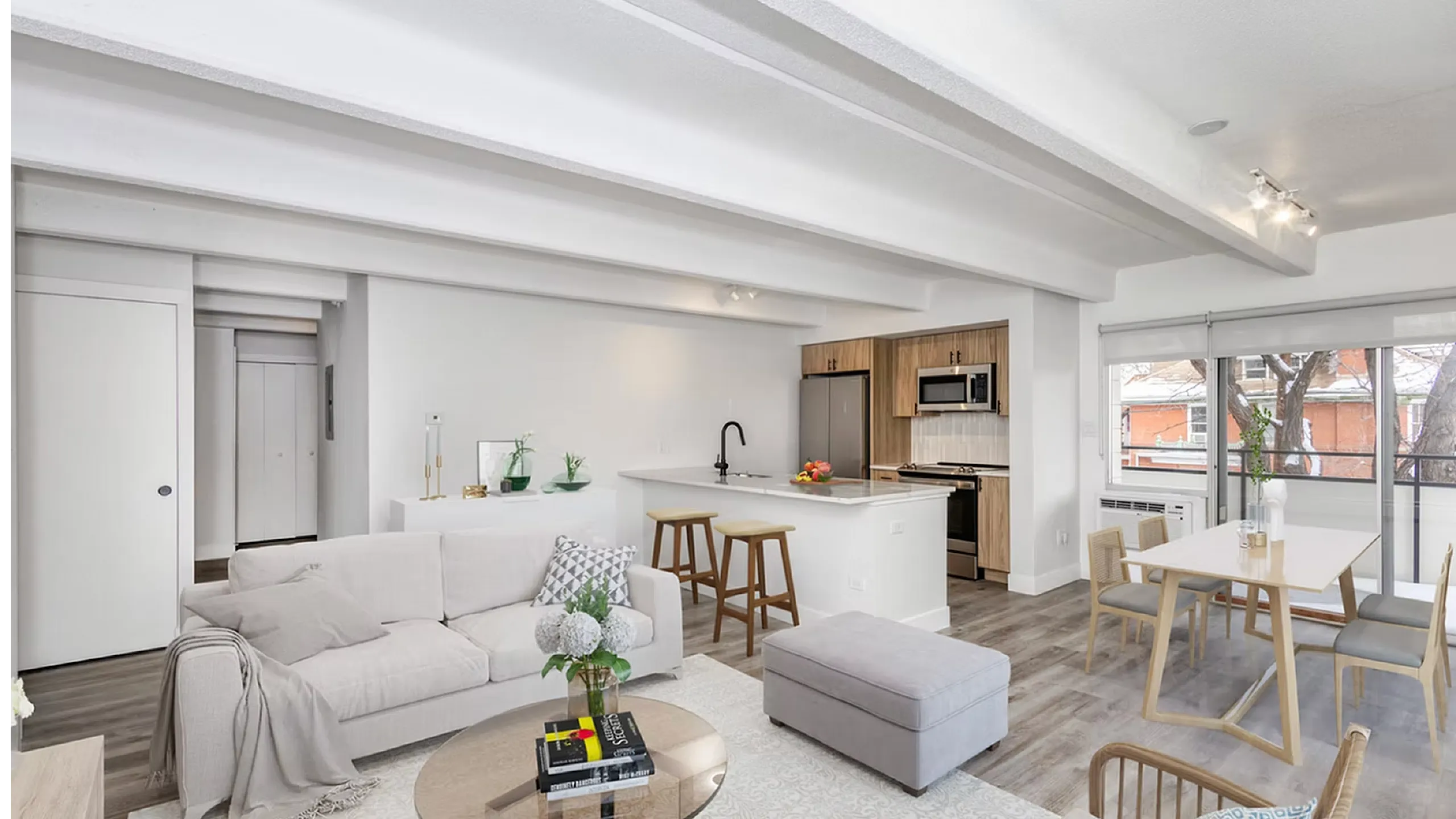 Modern and bright open-concept living space with cozy seating area, stylish kitchen with wood cabinetry, and a sunlit dining nook, ideal for relaxation and entertaining.