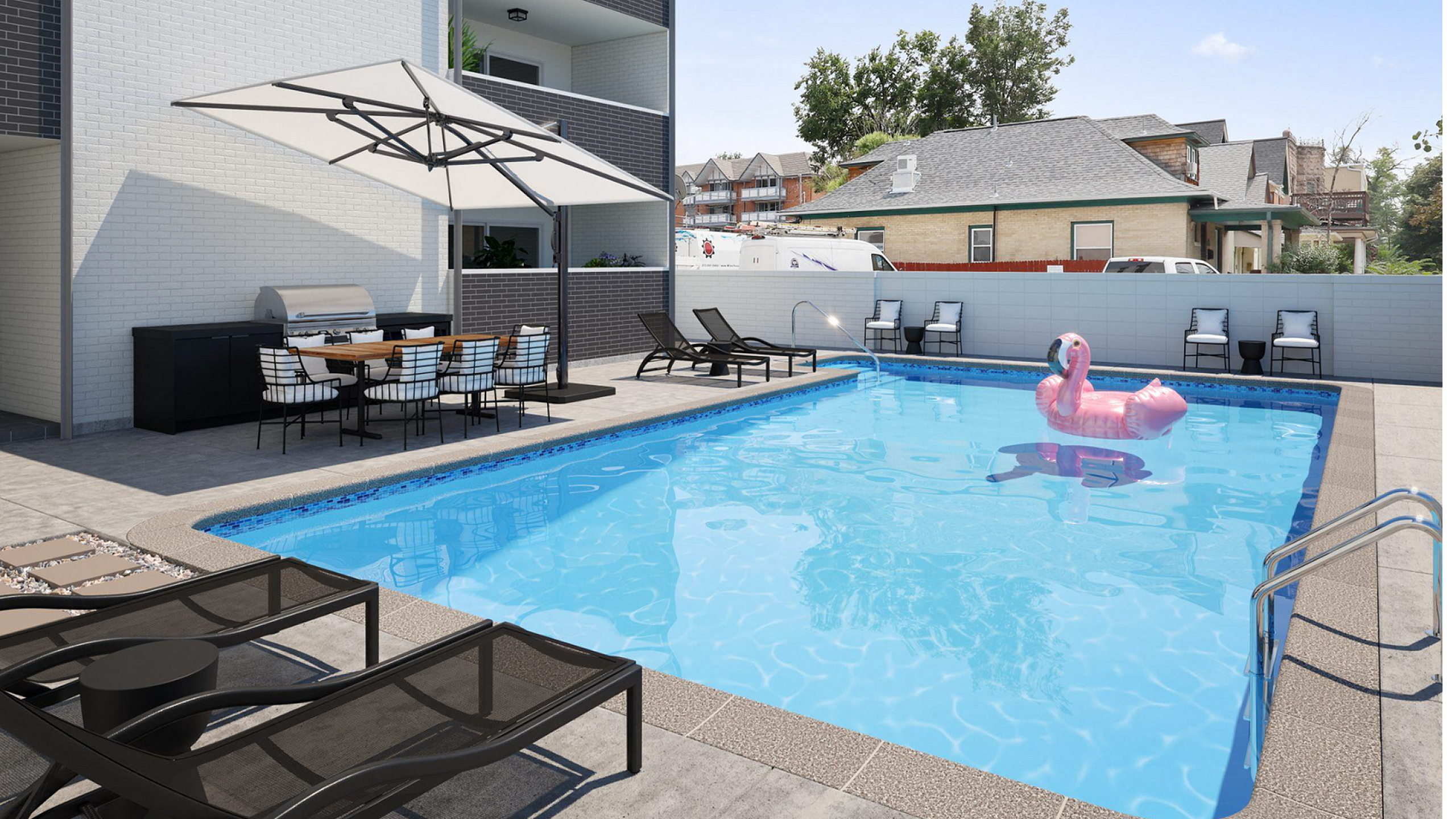 Inviting outdoor pool area with luxurious lounge chairs, a charming pink flamingo float, and a stylish dining setup under a large umbrella, perfect for entertainment and relaxation.