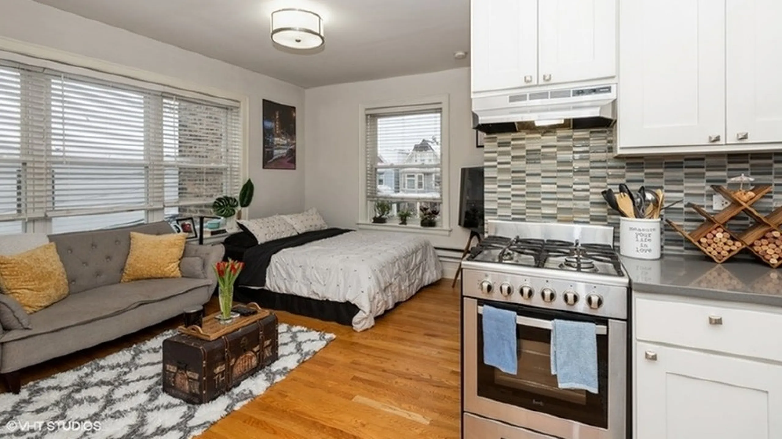 Charming studio apartment with cozy living area, modern kitchen, and stylish decor, featuring hardwood floors and ample natural light.