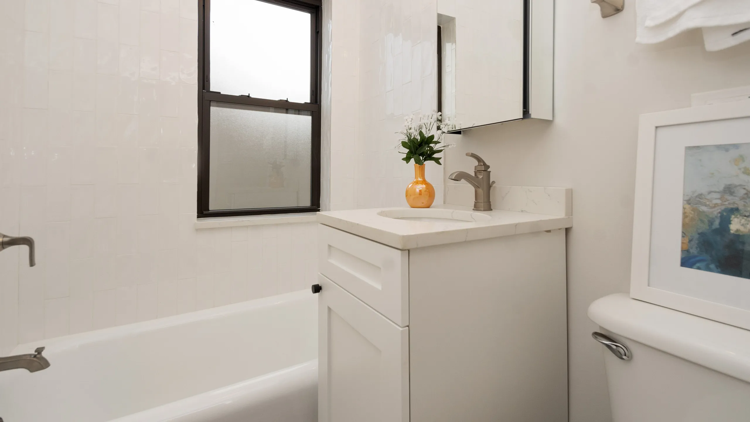 Cozy bathroom featuring a modern vanity, elegant fixtures, and a bright window for natural light.
