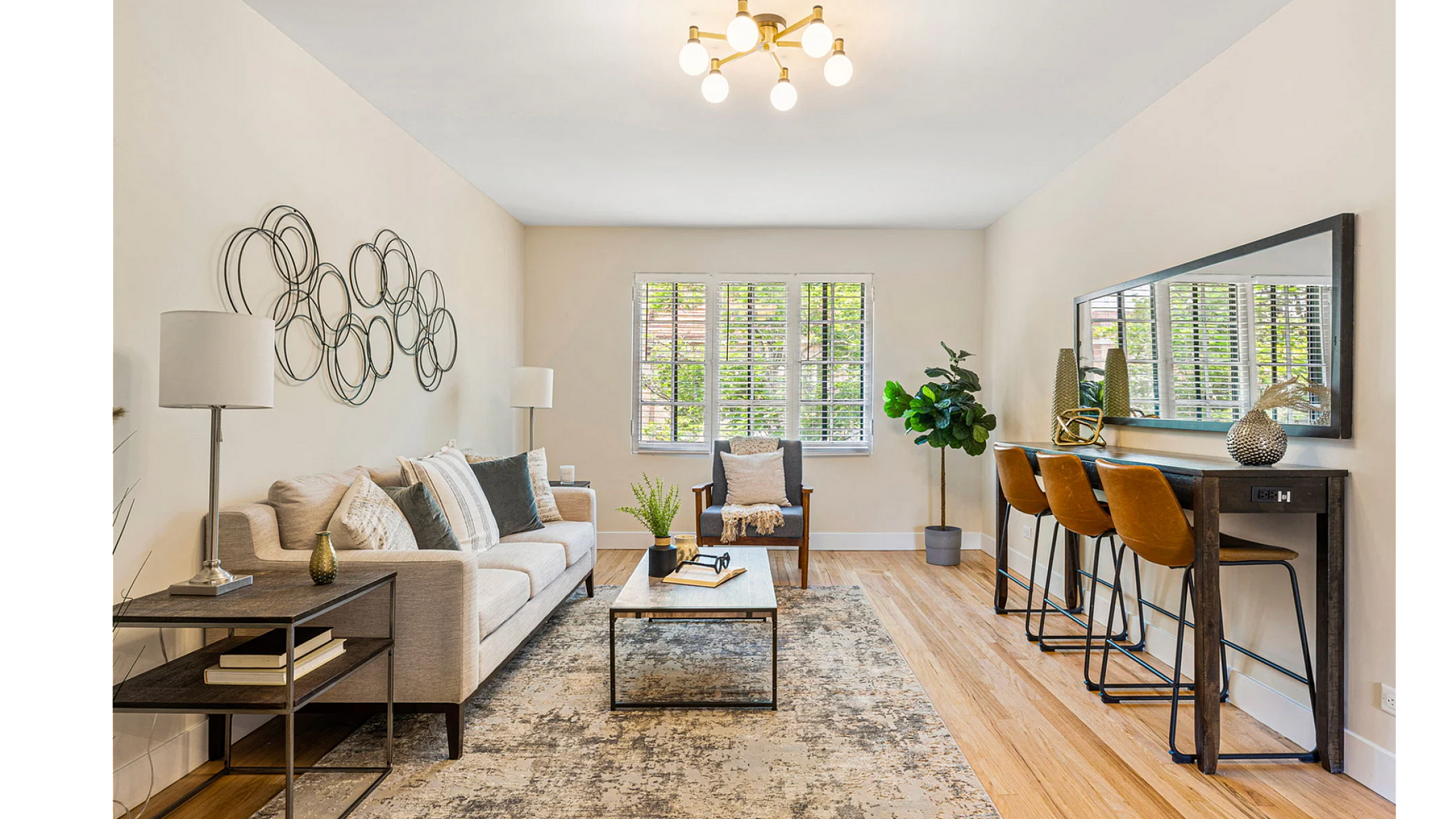Bright and inviting living room with stylish decor, featuring a comfortable sofa, chic wall art, and elegant lighting, perfect for relaxation.