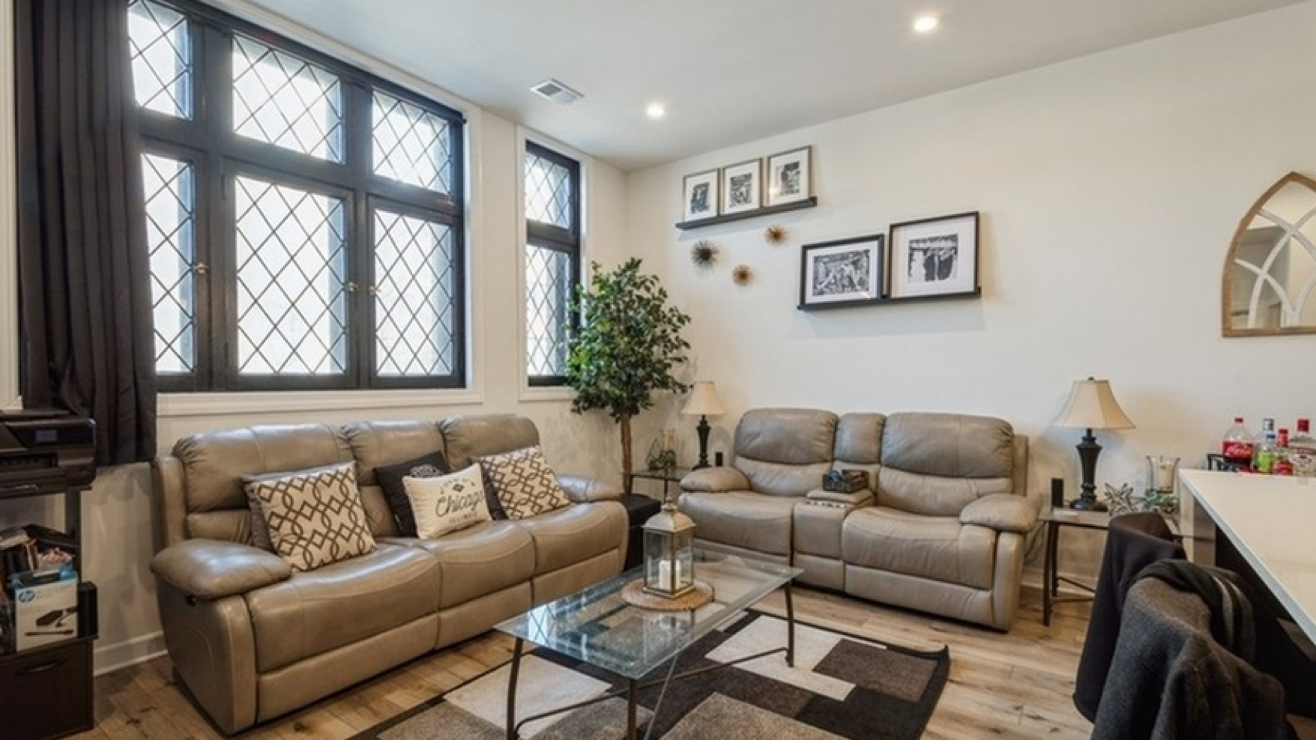 Inviting living room with stylish decor, plush leather couches, and large windows for natural light.