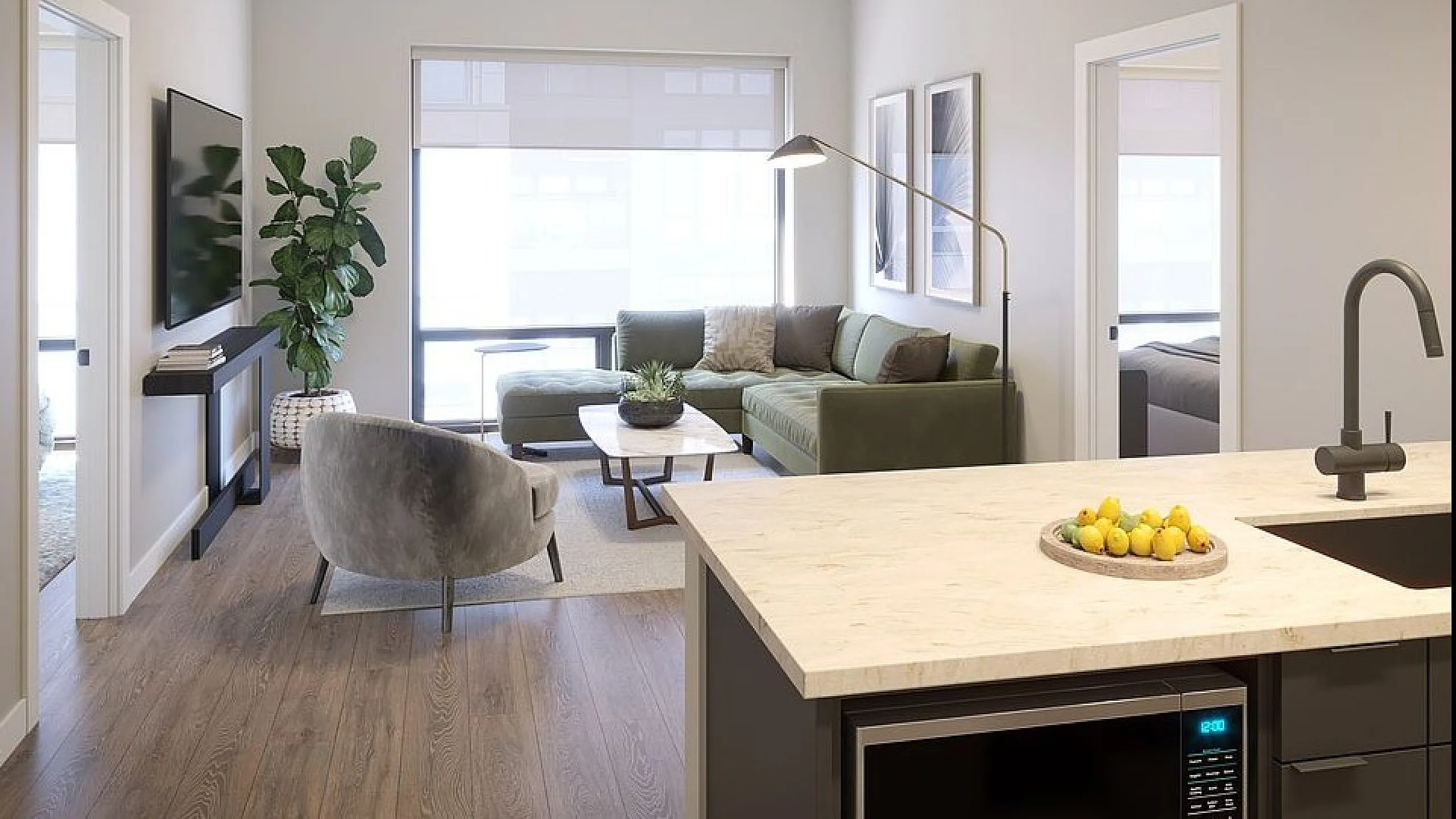 Modern apartment living room with natural light, featuring a cozy green sectional sofa, sleek decor, and a stylish open-plan kitchen with a breakfast bar.