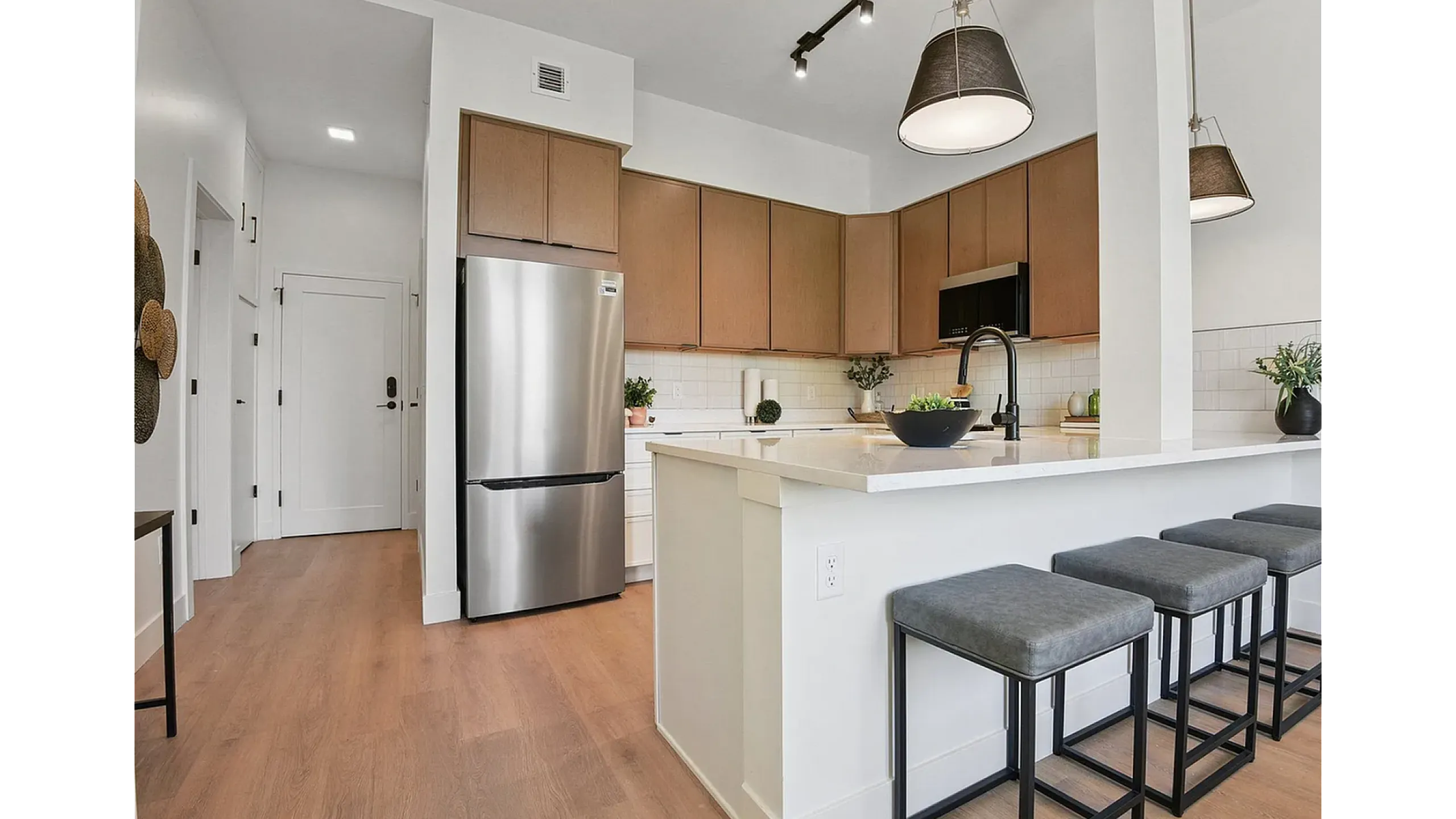 Modern kitchen with sleek stainless steel appliances, elegant wooden cabinetry, and a stylish island with bar seating.