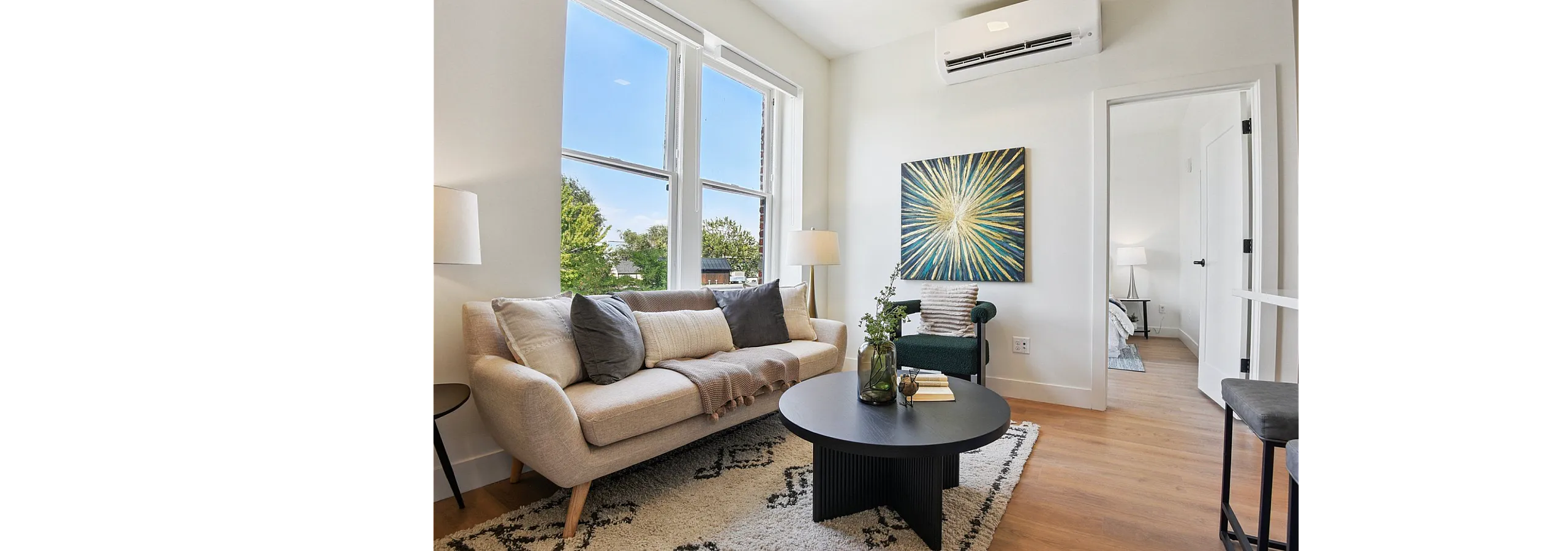 Bright and inviting living room with modern decor, featuring a plush sofa, stylish coffee table, and large window view.