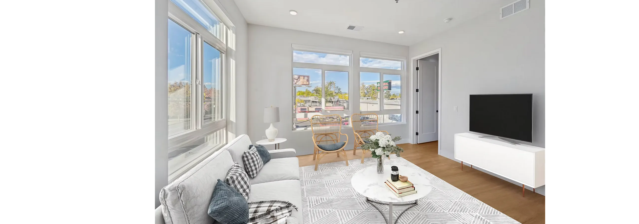 Bright and airy living room with contemporary decor, featuring large windows, cozy seating, and elegant furnishings perfect for relaxation.