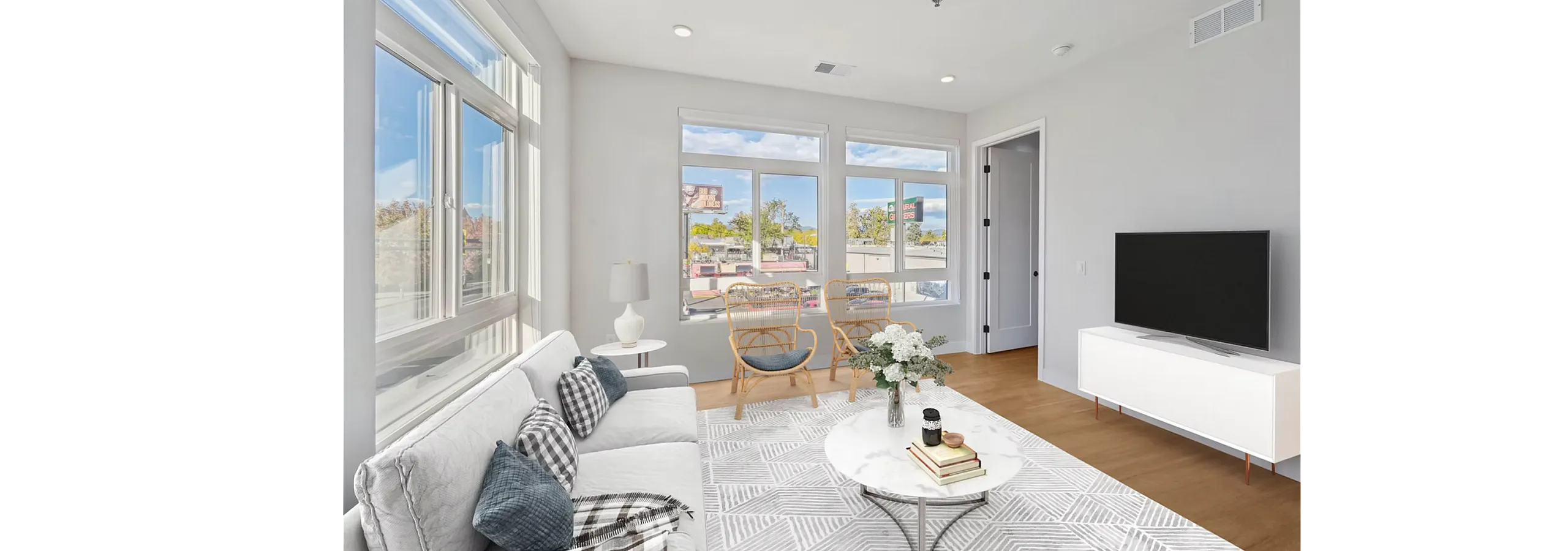 Bright and inviting living room with large windows, stylish furniture, and modern decor, offering a cozy and elegant ambiance for relaxation.