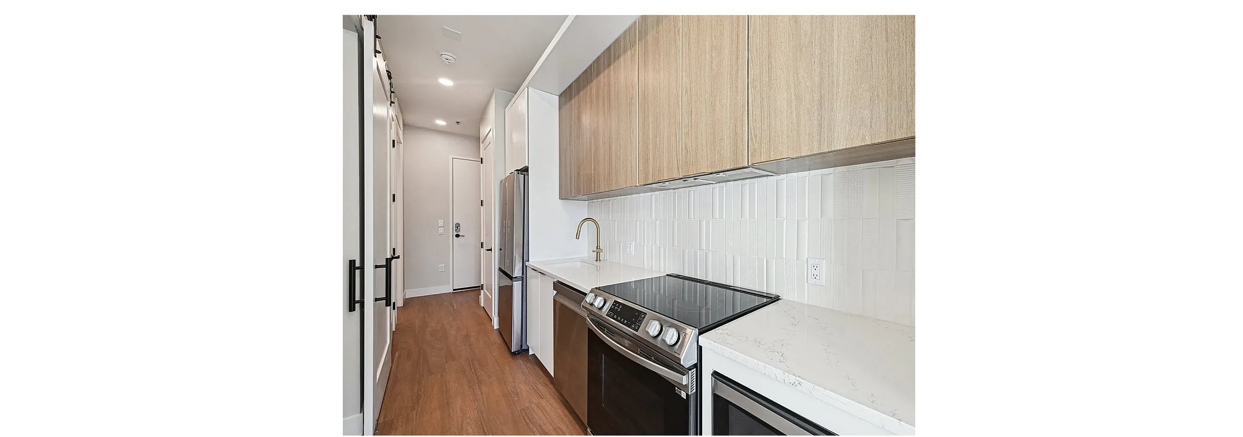 Sleek, modern kitchen showcasing elegant wood cabinetry, sparkling white countertops, stainless steel appliances, and chic tile backsplash.