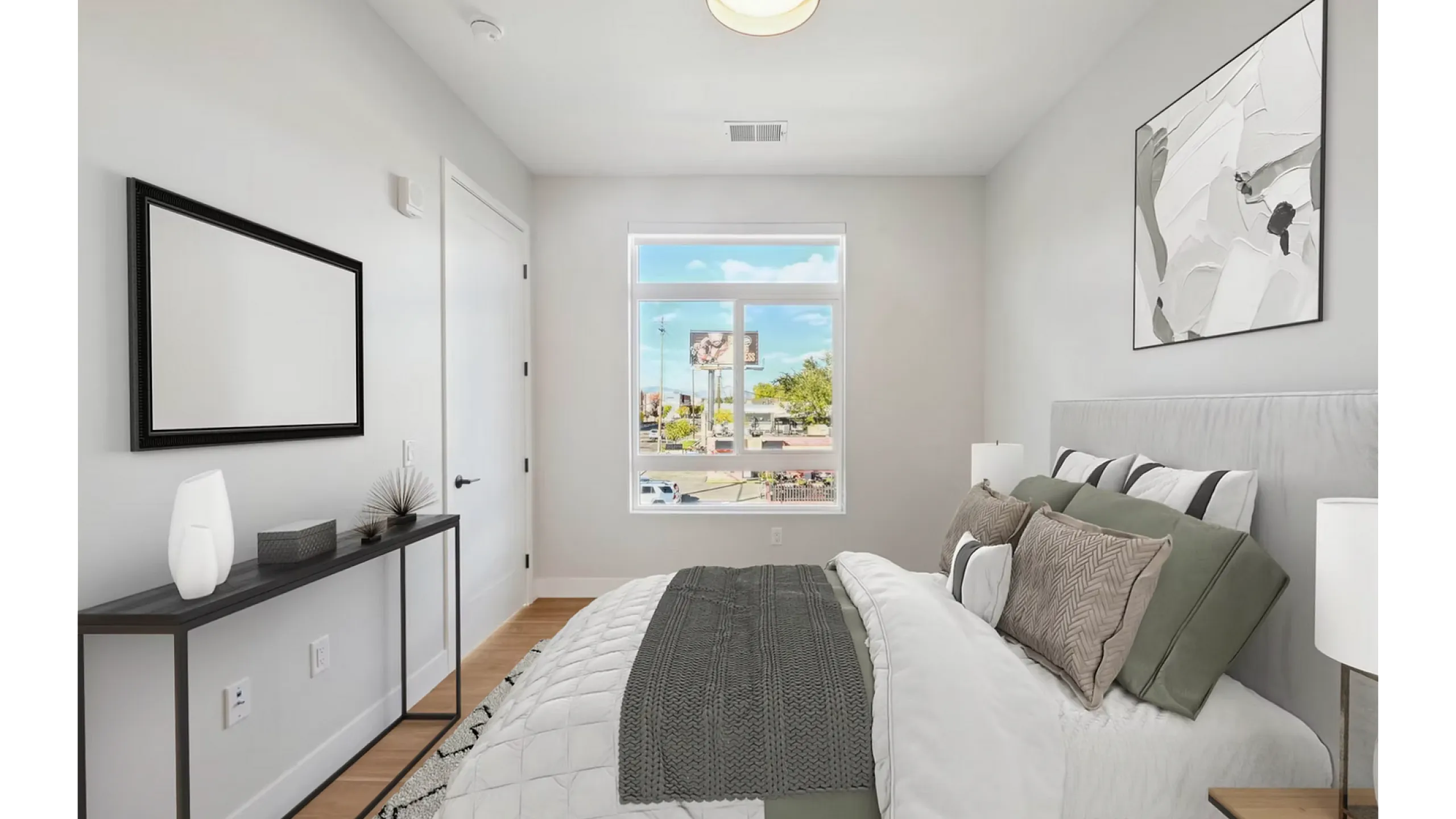 Bright and modern bedroom with stylish decor, large window letting in natural light, and inviting cozy bed setup.