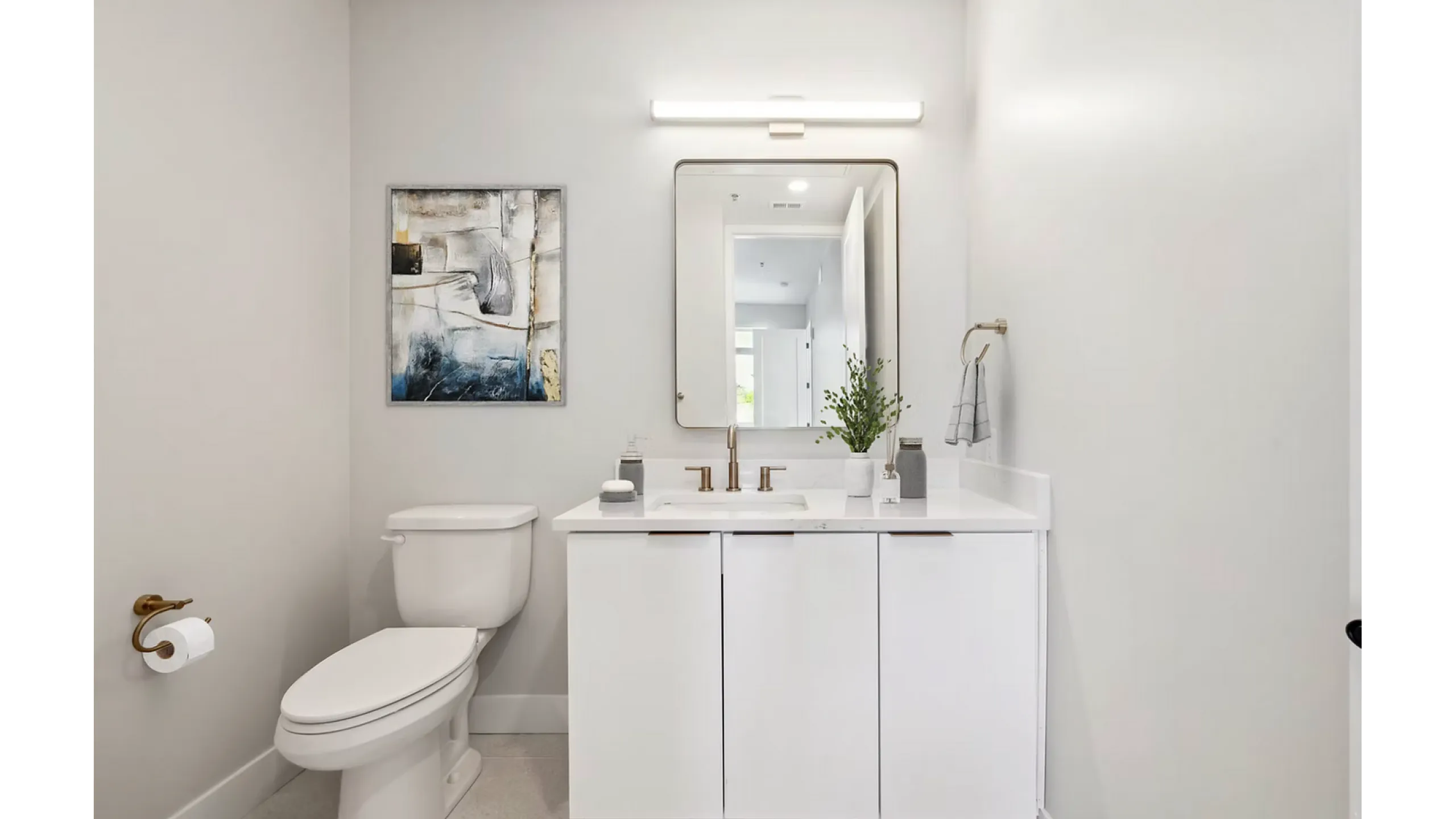 Contemporary bathroom with sleek white vanity, modern fixtures, and elegant wall art, creating a serene and stylish ambiance.