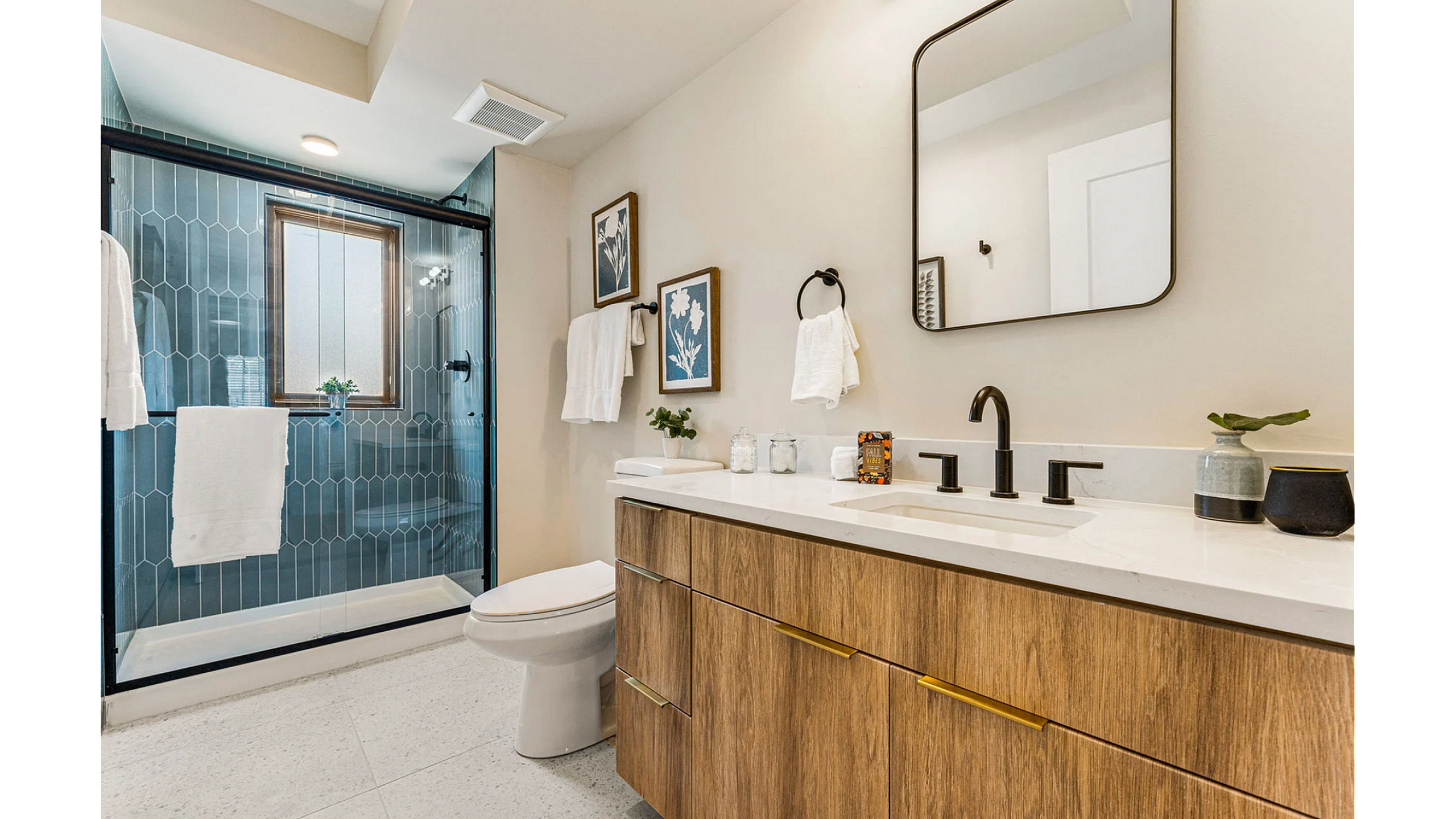 Elegant modern bathroom with wood accents, featuring a spacious vanity, sleek black fixtures, and stylish glass-enclosed shower.