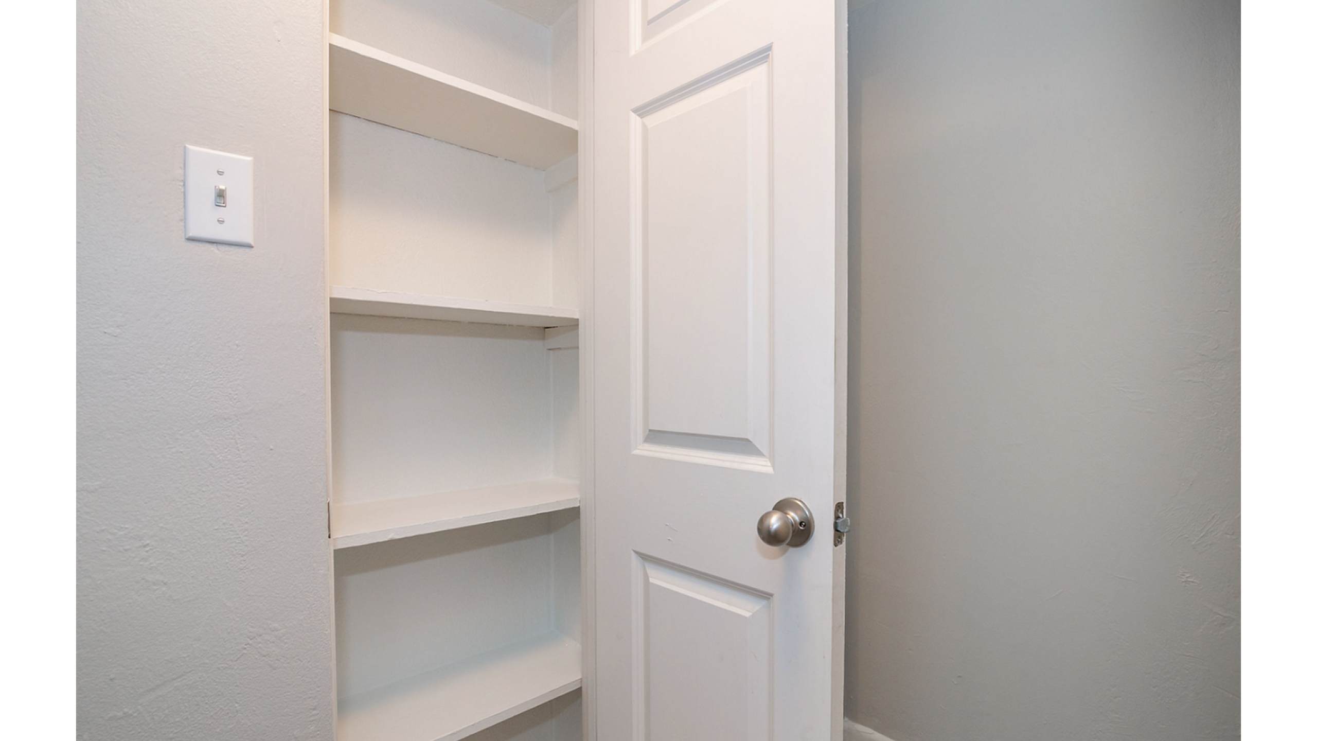 Sleek built-in shelving unit with ample storage space and a modern white door, perfect for organizing your essentials.