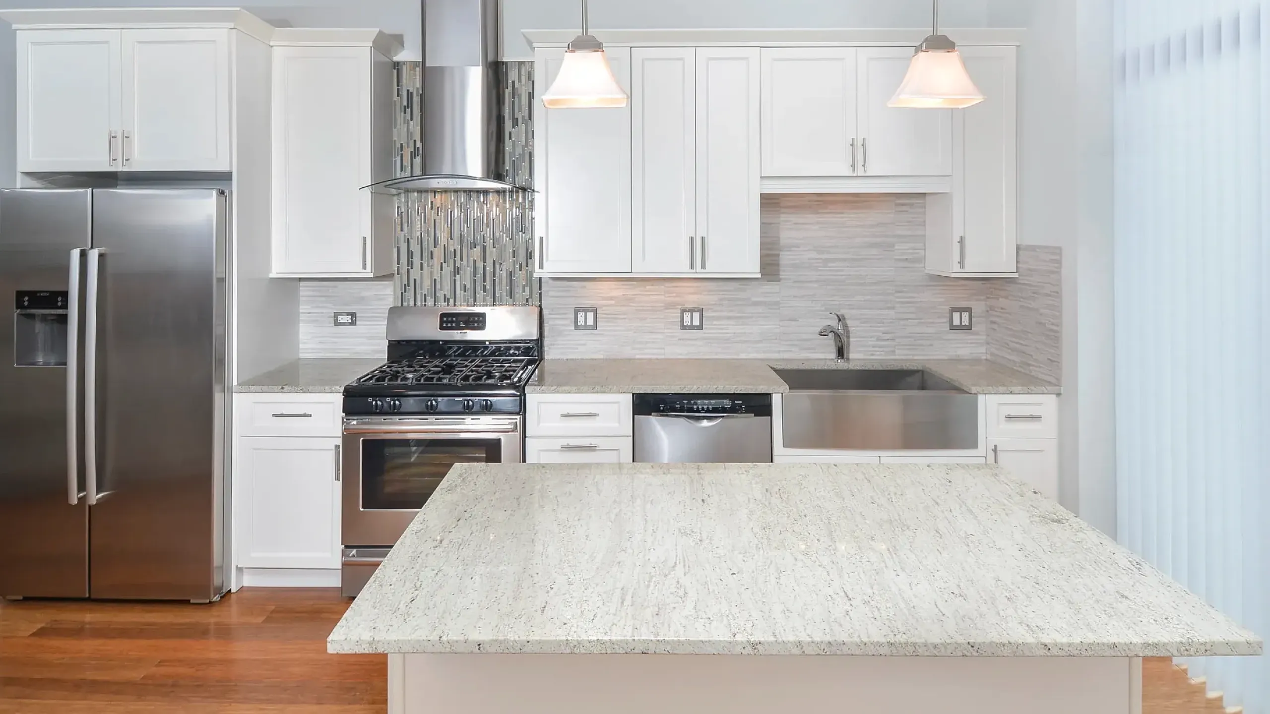 Modern kitchen with sleek appliances, elegant cabinetry, and a cozy work desk, perfect for a stylish urban apartment.