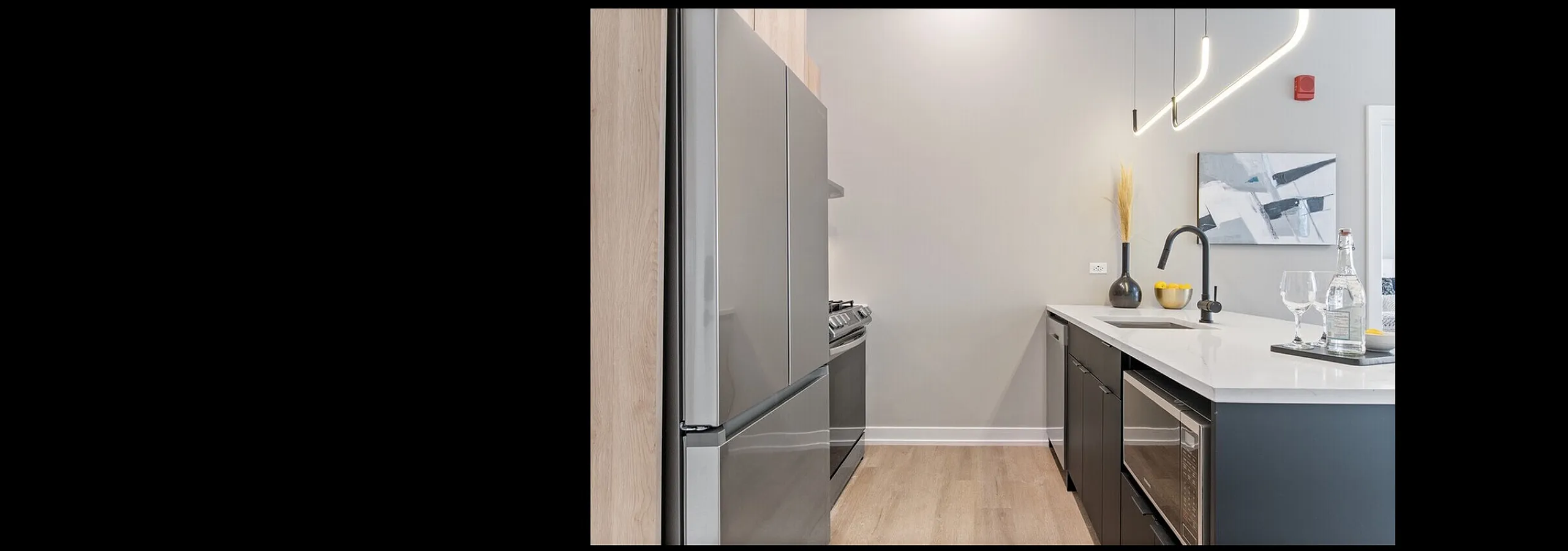 Sleek modern kitchen with minimalist design, featuring stainless steel appliances, elegant pendant lighting, and stylish decor accents.